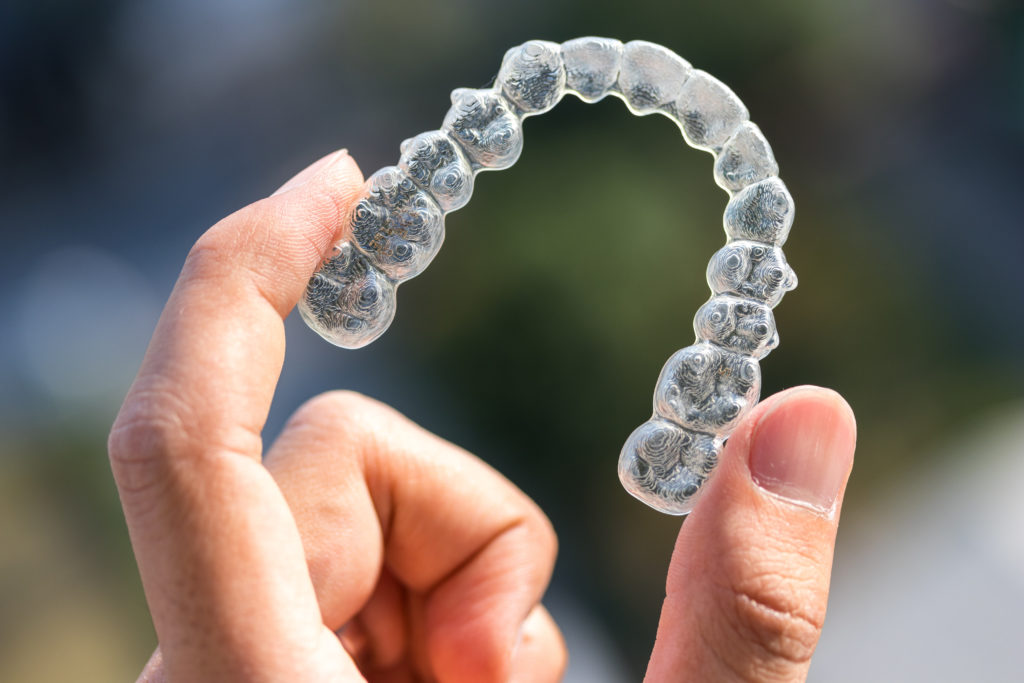 Hand Holding Invisalign Aligner